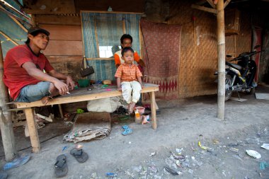 BALI, INDONESIA  APRIL 11: Unidentified children is sitting during his parents are working in a scavenging at the dump on April 11, 2012 on Bali. Bali daily produced 10,000 cubic meters of waste.